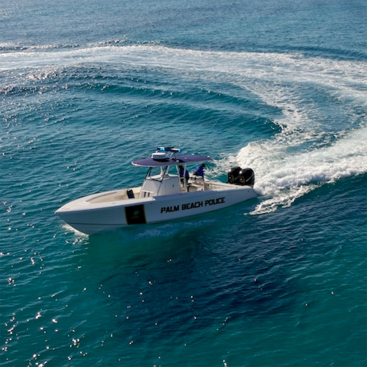 White police boat glides through the ocean.